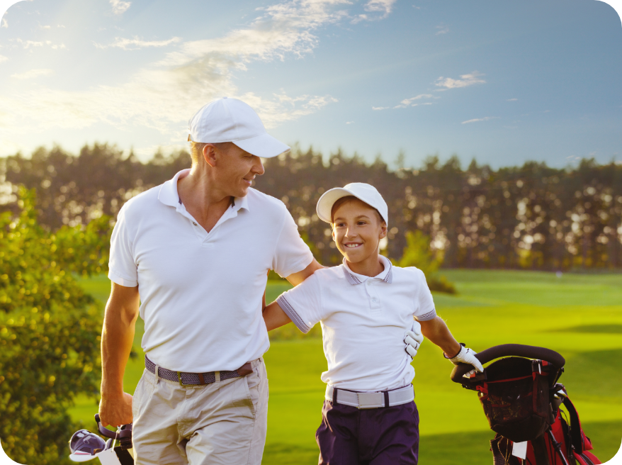 mężczyzna idący wraz z chłopcem po polu golfowym